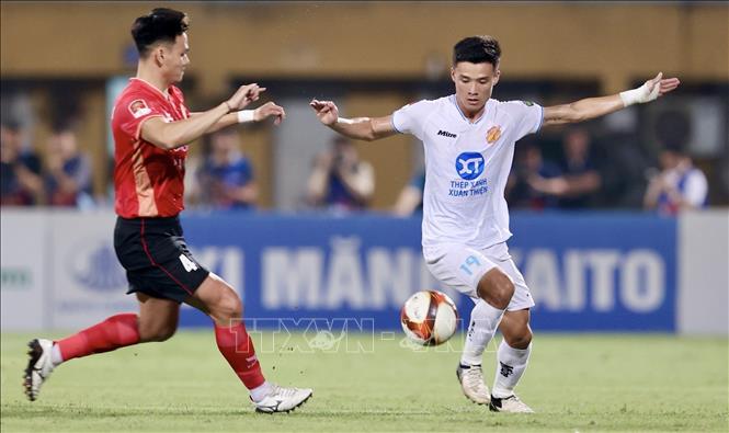 Pha tranh bóng giữa cầu thủ Hồ Tấn Tài (số 4, CAHN) và cầu thủ Trần Văn Đạt (số 19, Nam Định). Ảnh: TTXVN