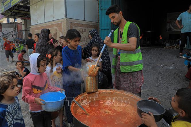 Các em nhỏ nhận thực phẩm cứu trợ tại thành phố Rafah, Dải Gaza, ngày 28/4/2024. Ảnh: THX/TTXVN