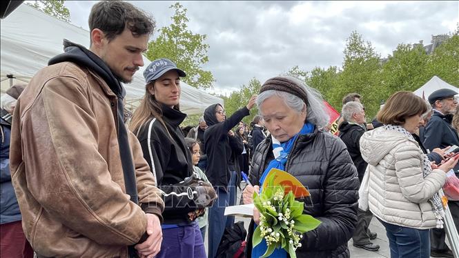 Bà Trần Tố Nga ký sách cho những người ủng hộ mình. Ảnh: Thu Hà - PV TTXVN tại Pháp