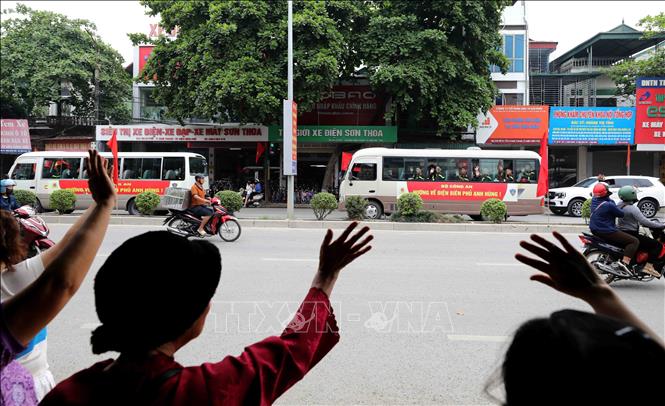 Nhân dân bên đường Võ Nguyên Giáp, thành phố Điện Biên Phủ hân hoan chào đón đoàn xe chở các chiến sĩ tham gia diễu binh, diễu hành. Ảnh: Trung Kiên - TTXVN