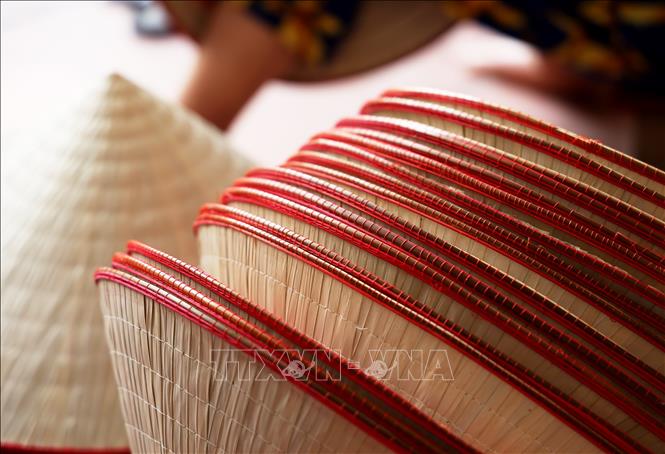 The edge of each conical hat is sewn together with a thin bamboo stick for durability. VNA Photo: Hồng Đạt