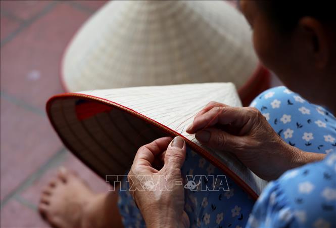 The brim of each conical hat is sewn together with a thin bamboo stick for durability. VNA Photo: Hồng Đạt