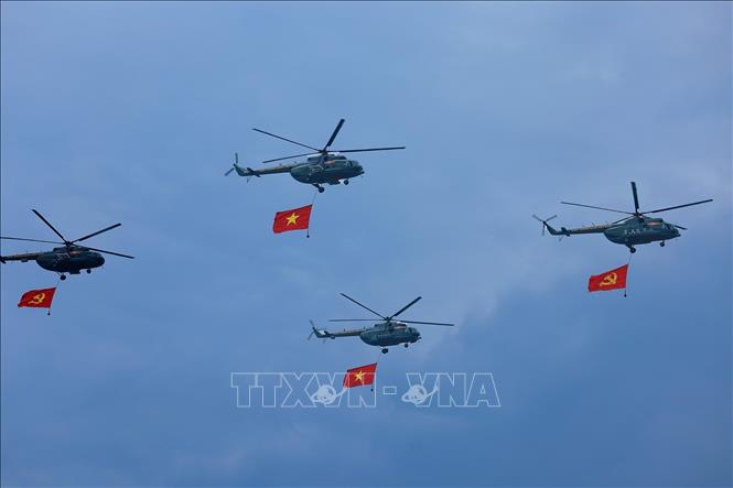 Máy bay trực thăng mang cờ Đảng, cờ Tổ quốc bay qua Lễ đài. Ảnh: Dương Giang-TTXVN
