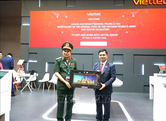 Thượng tướng Phùng Sĩ Tấn, Phó Tổng Tham mưu trưởng Quân đội nhân dân Việt Nam (bên trái) và Tổng giám đốc Viettel Hightech, Nguyễn Vũ Hà chụp ảnh lưu niệm tại gian hàng của Viettel tại triển lãm DSA 18. Ảnh: Hằng Linh-PV TTXVN tại Kuala Lumpur
