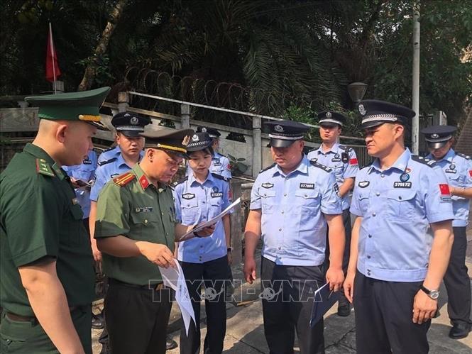 Lực lượng chức năng hai nước tiến hành các thủ tục trao trả 4 người Trung Quốc nhập cảnh trái phép vào Việt Nam. Ảnh: TTXVN phát