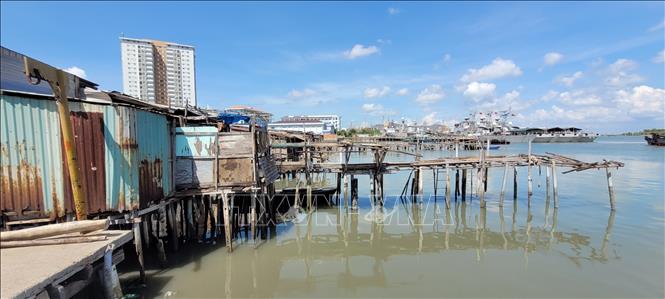 Nhiều hộ dân lấn chiếm mặt nước tại khu vực kênh Bến Đình để dựng nhà tạm. Ảnh: Hoàng Nhị - TTXVN.