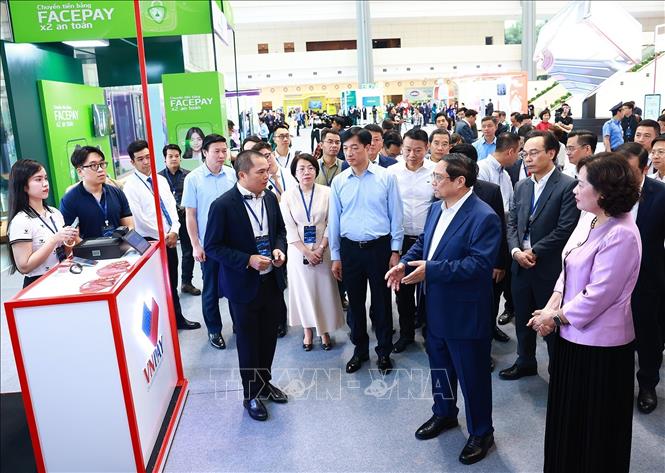 Thủ tướng Phạm Minh Chính tham quan trưng bày về ứng dụng chuyển đổi số trong lĩnh vực ngân hàng. Ảnh: Dương Giang-TTXVN