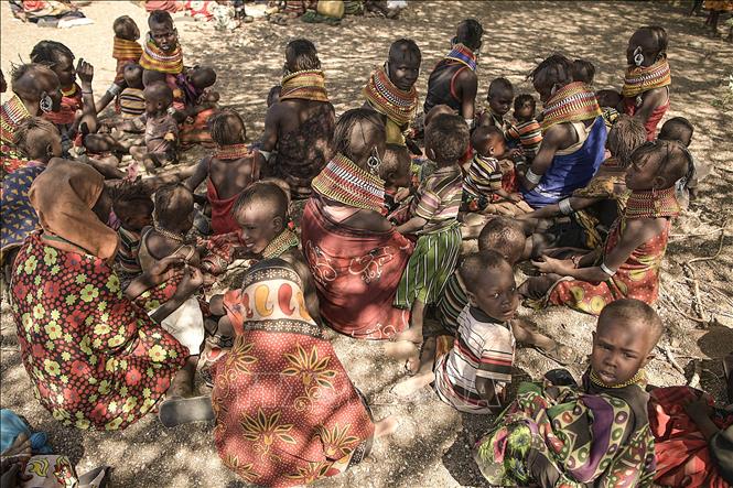(Tư liệu) Phụ nữ và trẻ em tránh nắng nóng dưới bóng cây tại làng Purapul, Marsabit, Kenya. Ảnh: AFP/TTXVN
