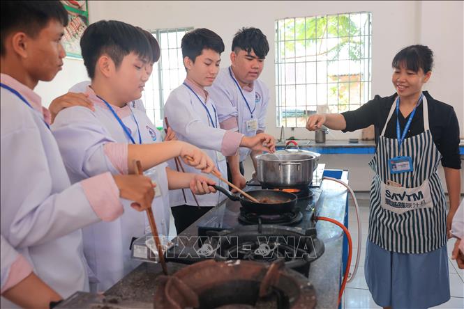Giáo viên Võ Thị Minh Yến hướng dẫn học sinh lớp 40NA2 (trường Trung cấp kinh tế Khánh Hoà) môn chế biến món ăn Việt Nam. Ảnh: Hoàng Hiếu - TTXVN