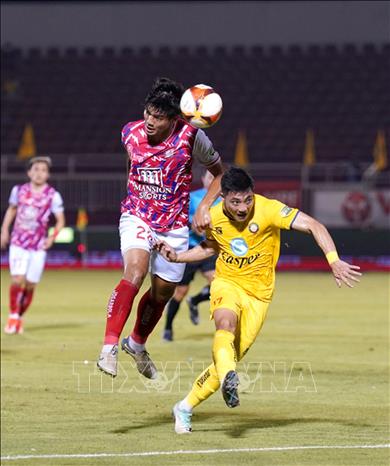 Pha tranh bóng giữa các cầu thủ CLB Thành phố Hồ Chí Minh (áo đỏ chấm trắng) và CLB Thanh Hóa (áo vàng). Ảnh: Thanh Vũ-TTXVN
