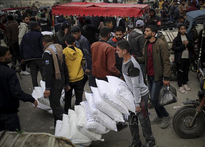Người tị nạn Palestine nhận hàng viện trợ từ UNRWA tại Dải Gaza ngày 3/3/2024. Ảnh: AFP/TTXVN