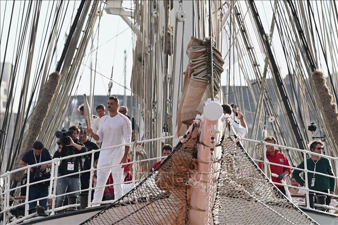 Nhà vô địch Olympic nội dung bơi 50m nam Florent Manaudou vinh dự rước đuốc Olympic Paris 2024 từ tàu Belem lên đất liền. Ảnh: THX/TTXVN