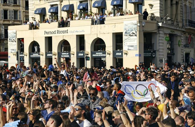 Người dân chào đón ngọn đuốc Olympic Paris 2024 tại cảng Marseille, Pháp ngày 8/5/2024. Kyodo/TTXVN