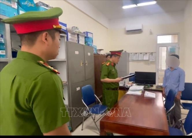 Cơ quan điều tra Công an huyện Mỹ Đức tống đạt quyết định tố tụng đối với bị can trong vụ án. Ảnh TTXVN phát

