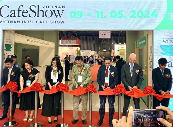 Delegates cut the red ribbon to open the exhibition. VNA Photo: Mỹ Phương