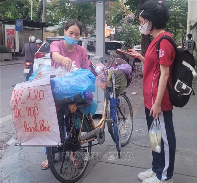 Các quán hàng rong bán đồ ăn uống đang thu hút nhiều học sinh tiêu thụ với mức giá rất rẻ, tiềm ẩn nguy cơ mất an toàn. Ảnh: Phương Anh-TTXVN