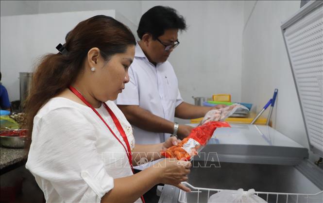 Đoàn kiểm tra nguyên liệu chế biến thức ăn tại 1 cơ sở kinh doanh ăn uống. Ảnh: Hồng Thái - TTXVN