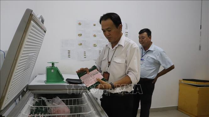 Đoàn kiểm tra nguyên liệu chế biến thức ăn tại 1 cơ sở kinh doanh ăn uống. Ảnh: Hồng Thái - TTXVN