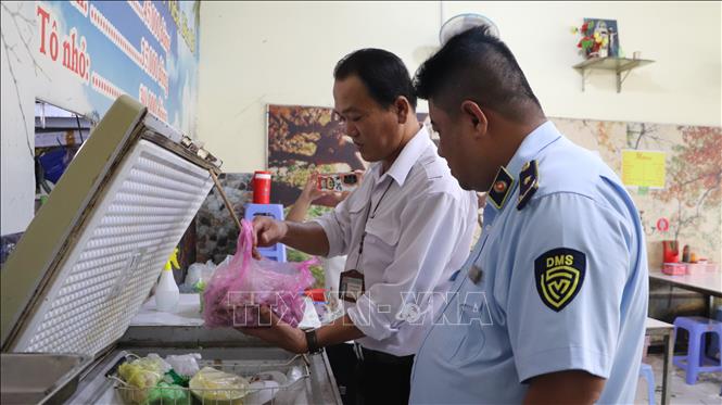 Đoàn kiểm tra nguyên liệu chế biến thức ăn tại 1 cơ sở kinh doanh ăn uống. Ảnh: Hồng Thái - TTXVN