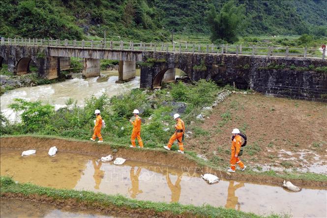 Công nhân điện lực huyện Trùng Khánh đi kiểm tra lưới điện tại xã Phong Nậm. Ảnh: Huy Hùng - TTXVN