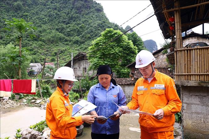 Công nhân điện lực Trùng Khánh tuyên truyền dùng điện an toàn, tiết kiệm cho người dân xóm Khuổi Ky, xã Đàm Thủy. Ảnh: Huy Hùng - TTXVN