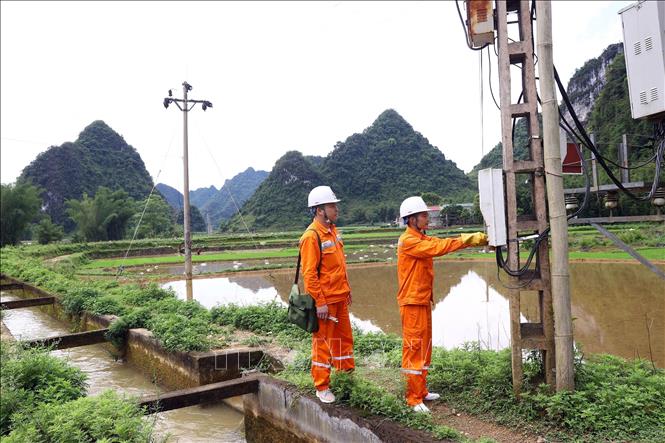 Công nhân điện lực Trùng Khánh kiểm tra công tơ điện cho các hộ dân tại xã Phong Nậm. Ảnh: Huy Hùng - TTXVN