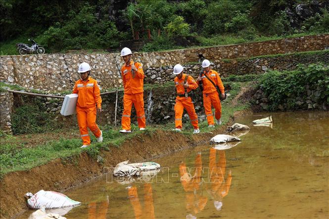 Công nhân điện lực huyện Trùng Khánh đi kiểm tra lưới điện tại xã Phong Nậm. Ảnh: Huy Hùng - TTXVN