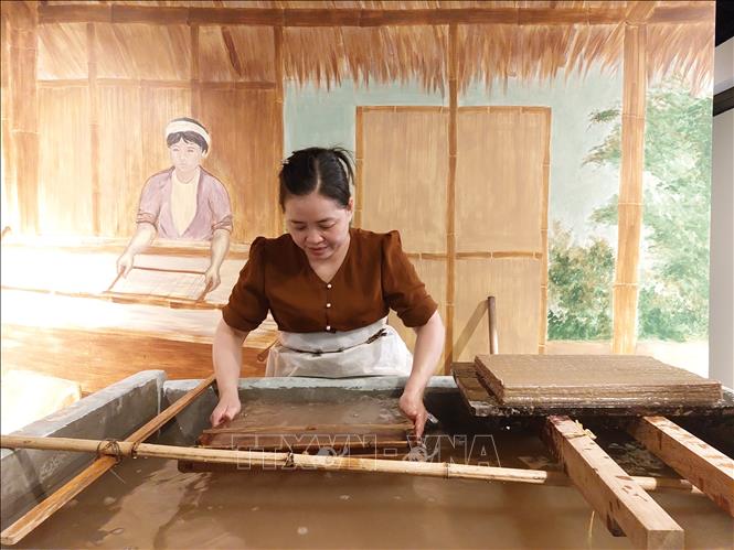 Chị Nguyễn Thị Độ đang thực hiện công đoạn xeo giấy Dó. Ảnh: Minh Ngọc - TTXVN phát
