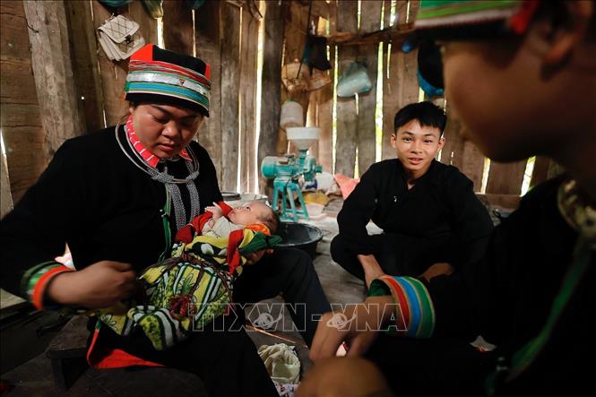 Cô đỡ Lý Thị Tìn tắm cho trẻ sơ sinh tại thôn Cốc Peng, xã Ngam La, huyện Yên Minh. Ảnh: Minh Quyết - TTXVN