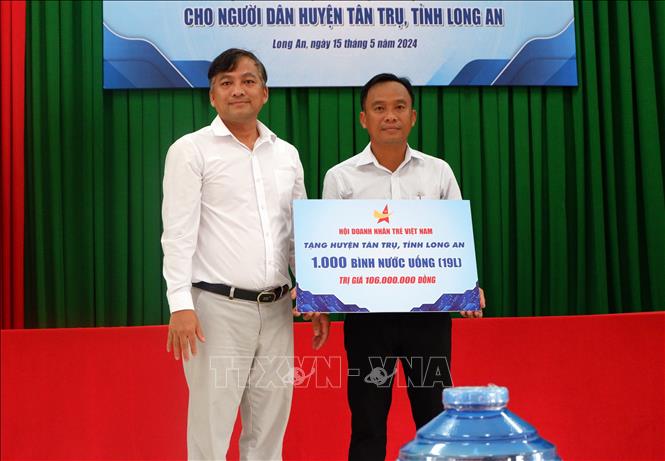Ông Dương Long Thành, Phó Chủ tịch Trung ương Hội Doanh nhân trẻ Việt Nam, Chủ tịch Hội Doanh nhân Rrẻ tỉnh Long An trao tặng nước ngọt cho người dân huyện Tân Trụ. Ảnh: Đức Hạnh - TTXVN 