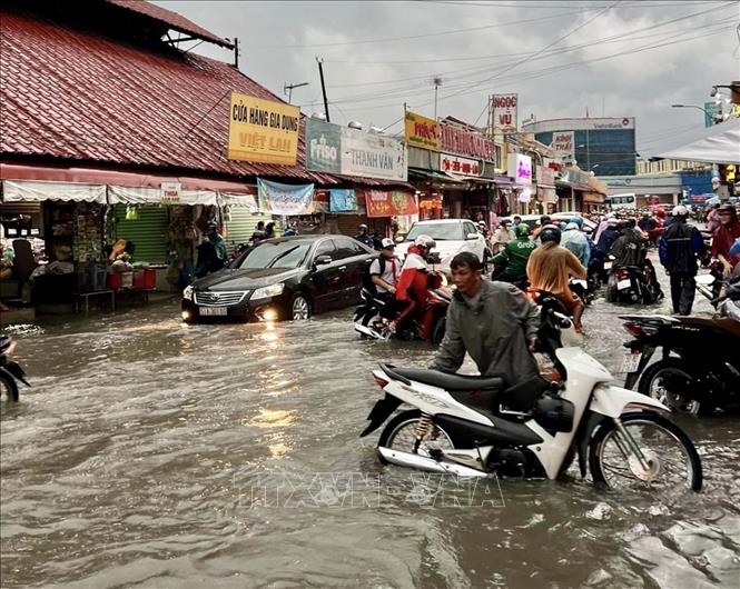 Nước ngập lênh láng tại khu vực Chợ Thủ Đức (thành phố Thủ Đức, Thành phố Hồ Chí Minh). Ảnh: Hồng Giang - TTXVN