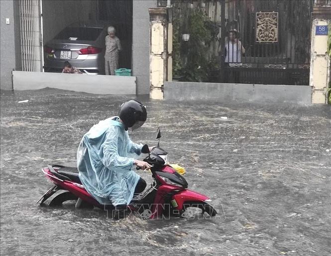 Nước ngập lút bánh xe mô tô trên đường Dương Văn Cam (thành phố Thủ Đức, Thành phố Hồ Chí Minh). Ảnh: TTXVN phát