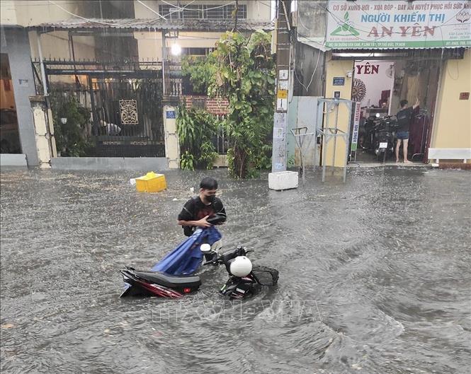 Nước ngập sâu khiến nhiều phương tiện di chuyển qua đường Dương Văn Cam (thành phố Thủ Đức, Thành phố Hồ Chí Minh) bị chết máy. Ảnh: TTXVN phát