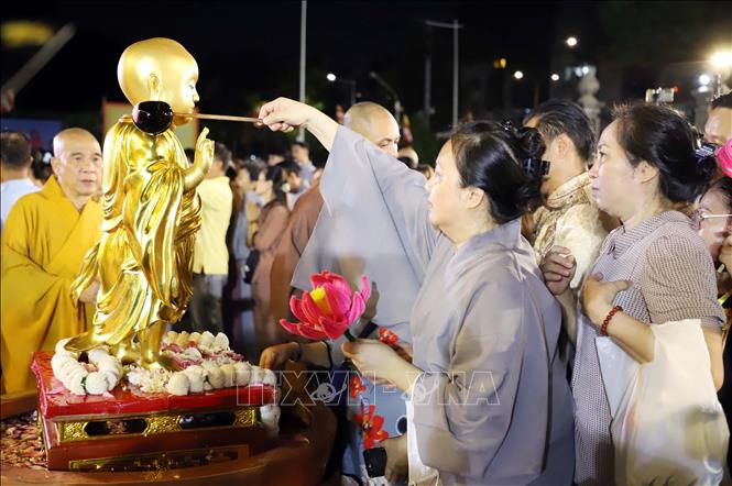People perform the Buddha bath rite at Vietnam Quoc Tu. VNA Photo: Xuân Khu