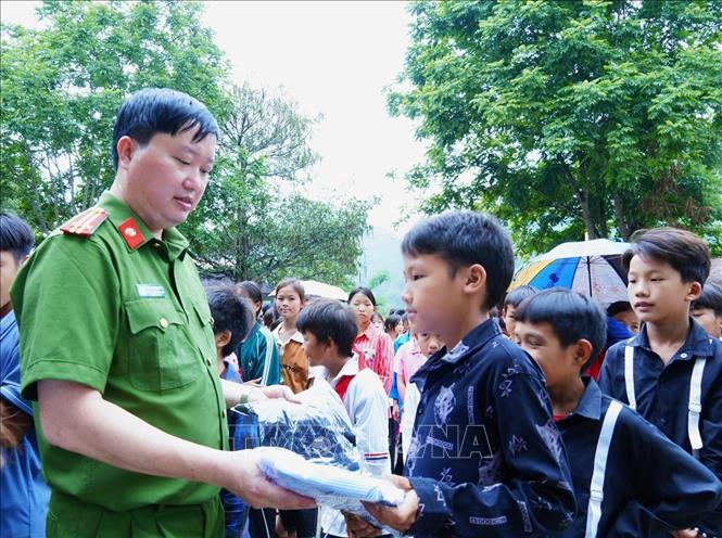 Trung tá Giàng Xuân Thắng, Trưởng Công an huyện Mèo Vạc tặng quà học sinh Trường PTDTBT Tiểu học xã Niêm Tòng. Ảnh TTXVN phát
