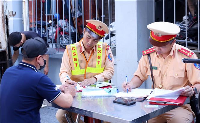 Lực lượng CSGT thuộc Tổ công tác đặc biệt lập biên bản xử lý 1 trường hợp vi phạm an toàn giao thông. Ảnh: Phạm Kiên - TTXVN