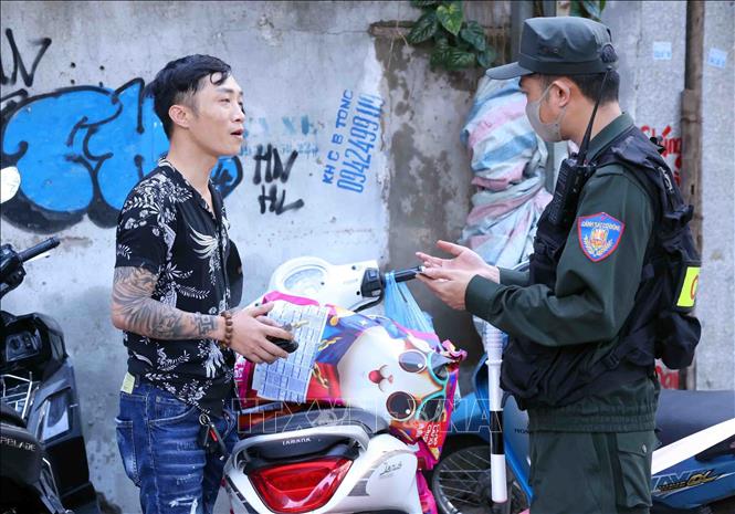 Cán bộ, chiến sĩ thuộc Tổ công tác đặc biệt Công an TP Hà Nội dừng xe, kiểm tra và xử lý 1 trường hợp vi phạm trật tự an toàn giao thông. Ảnh: Phạm Kiên - TTXVN