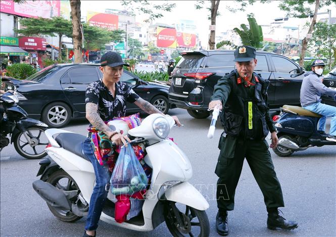 Chiến sĩ thuộc Tổ công tác đặc biệt Công an TP Hà Nội dừng xe, kiểm tra và xử lý 1 trường hợp vi phạm trật tự an toàn giao thông. Ảnh: Phạm Kiên - TTXVN