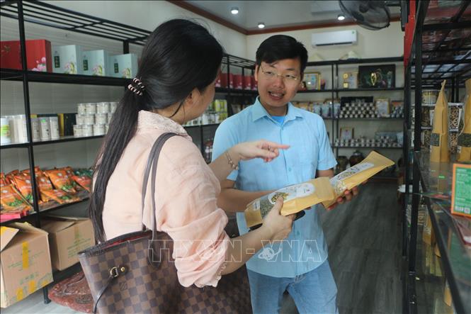 Giới thiệu sản phẩm sen quê Bác tới du khách tham quan. Ảnh: Bích Huệ - TTXVN