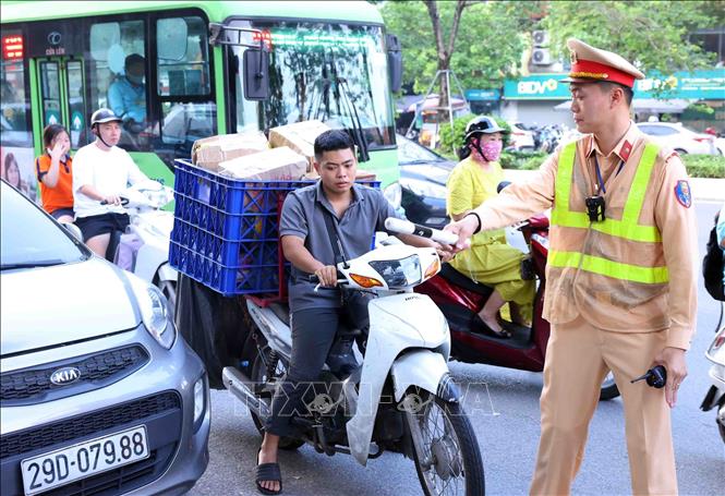 Chiến sĩ thuộc Tổ công tác đặc biệt Công an TP Hà Nội dừng xe, kiểm tra và xử lý 1 trường hợp vi phạm trật tự an toàn giao thông tại tuyến phố Ô Chợ Dừa, quận Đống Đa. Ảnh: Phạm Kiên - TTXVN