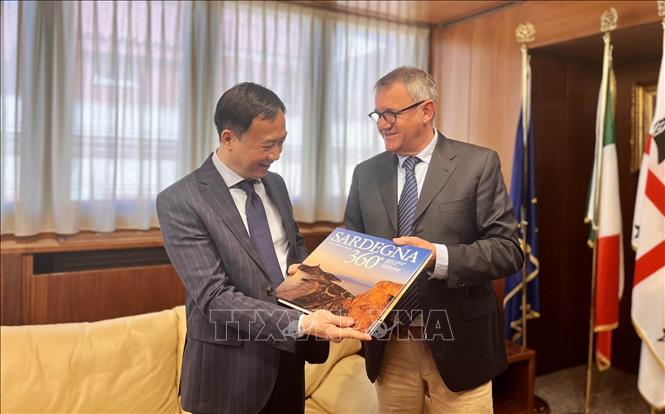 Ông Giampietro Comandini, Chủ tịch Hội đồng Vùng Sardinia tặng sách cho Đại sứ Việt Nam tại Italy Dương Hải Hưng. Ảnh: TTXVN phát