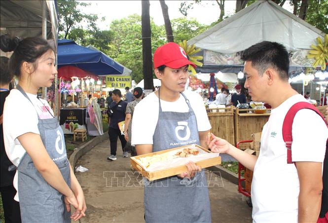 Khách tham quan thưởng thức các loại bánh mì được chế biến từ ngũ cốc. Ảnh: Mỹ Phương – TTXVN
