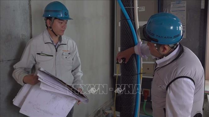 Kỹ sư Hoàng Nông Bộ trao đổi công việc với đồng nghiệp Nhật Bản. Ảnh: Nguyễn Tuyến - Pv TTXVN tại Nhật Bản