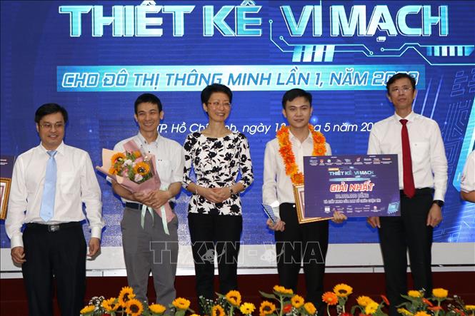 Ông Nguyễn Anh Thi, Trưởng BQL Khu Công nghệ cao TP Hồ Chí Minh cùng các đại biểu trao giải nhất cho thí sinh Phạm Thế Hùng với dự án “Thiết kế chip Analog Front-end nhiễu thấp tái cấu hình ứng dụng thu nhận tín hiệu từ cảm biến trên công nghệ CMOS 180nm”. Ảnh: Thanh Vũ-TTXVN
