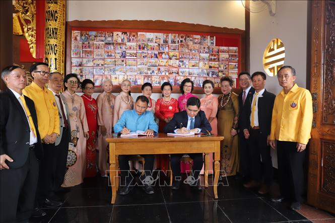 Đại sứ Phạm Việt Hùng (ngồi, bên phải ảnh) và đại diện địa phương tỉnh Nakhon Phanom ghi sổ lưu niệm tại Khu tưởng niệm Chủ tịch Hồ Chí Minh. Ảnh: Đỗ Sinh - P/v TTXVN tại Thái Lan