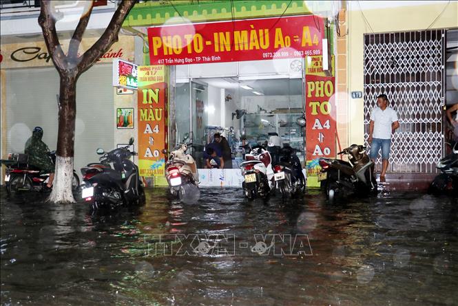 Người dân sống ở mặt đường Trần Hưng Đạo, thành phố Thái Bình ngăn để nước không tràn vào nhà. Ảnh Vũ Quang – TTXVN