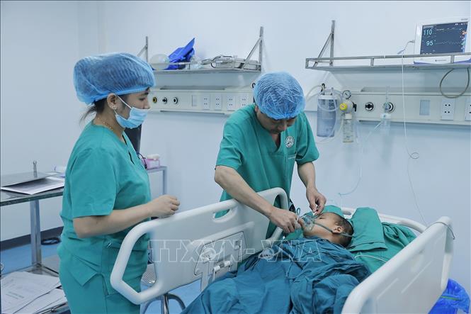 Bác sĩ, điều dưỡng chăm sóc cho bệnh nhân hậu phẫu tại khoa Phẫu thuật – Gây mê hồi sức. Ảnh: Minh Quyết – TTXVN