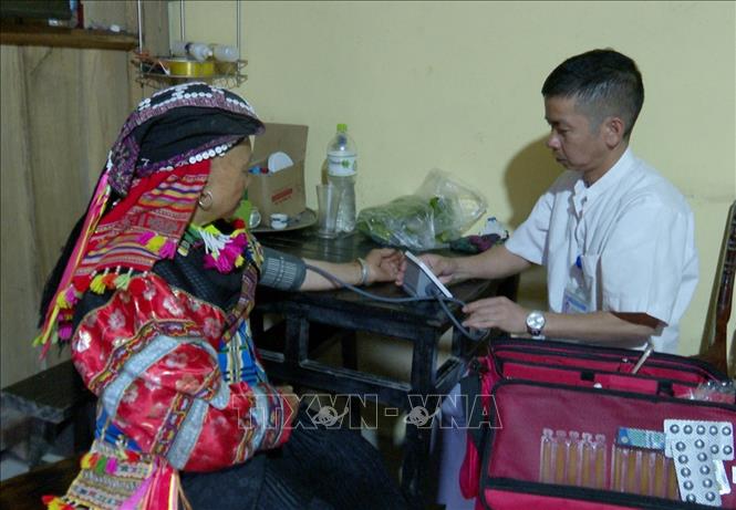 Nhân viên y tế cơ sở đến tận nhà người dân để thăm, khám bệnh. Ảnh: TTXVN phát