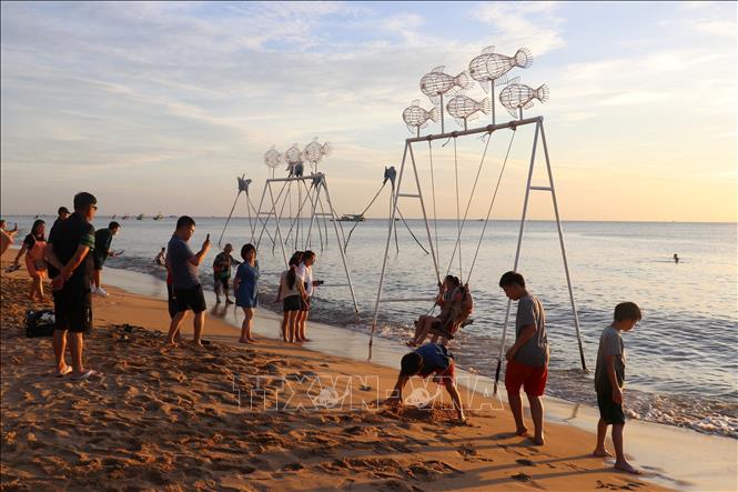 Tourists enjoy sunset on Bai Truong beach. VNA Photo