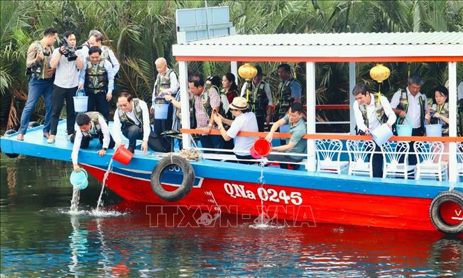 Các đại biểu thả cá sau lễ kỷ niệm Ngày Quốc tế đa dạng sinh học năm 2024. Ảnh: Trần Tĩnh - TTXVN